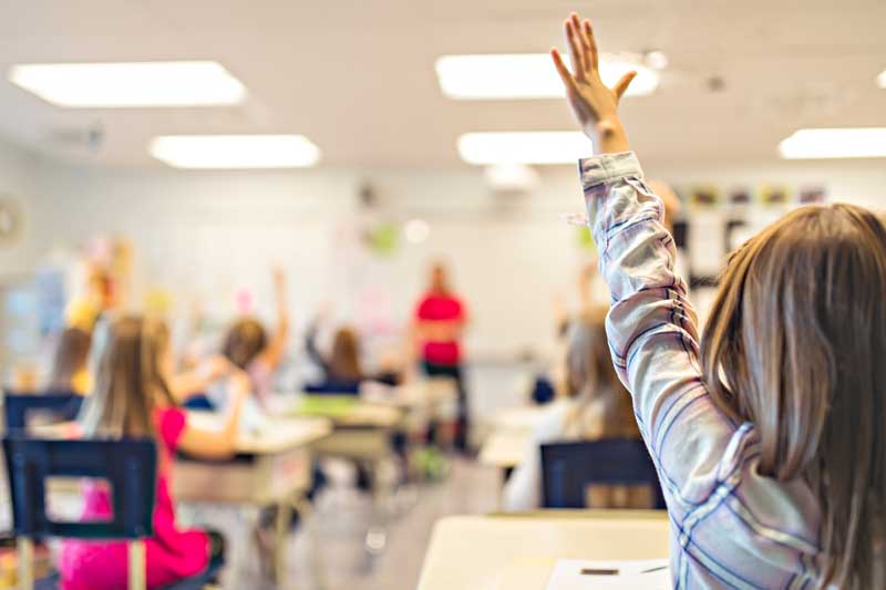 Girl in class raising her hand