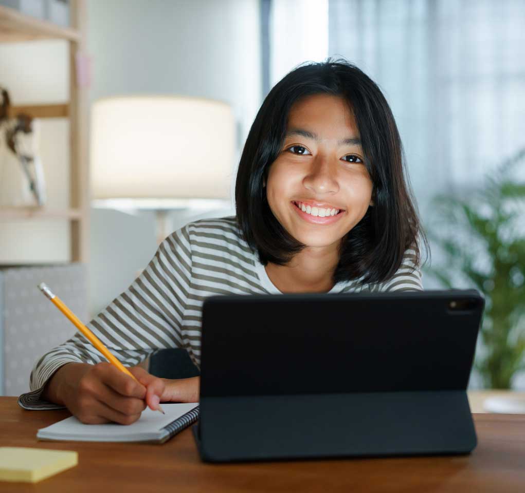 Teenage girl writing some notes and smiling